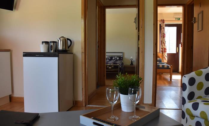 Communal space with kitchenette, looking into bedroom one and bedroom two
